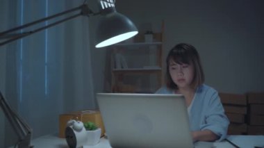 Sme online kontrol ürünü Sahibi Asyalı genç girişimci iş kadını bilgisayara kaydetmek ve evde gece geç saatlerde çalışan kahve içme. Ev ofis konseptinde küçük işletme sahibi.