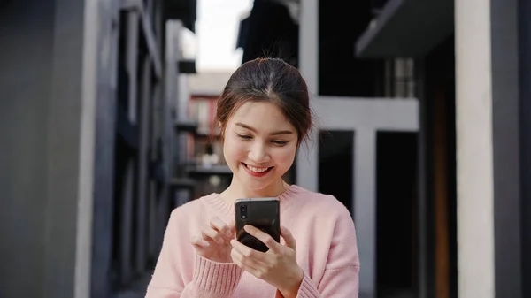 Iloinen aasialainen reppumatkailija bloggaaja nainen, joka käyttää älypuhelinta suuntaan ja etsii sijaintikarttaa matkustaessaan Chinatownissa Pekingissä, Kiinassa. Elämäntapa reppu turisti matka loma käsite . — kuvapankkivalokuva