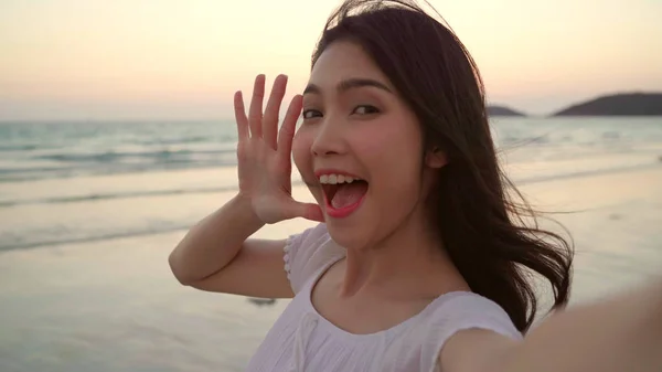 Turista ázsiai nő selfie a strandon, a fiatal, szép nő boldog mosolygós mobiltelefonján vesz selfie a tengerparton tenger közelében naplemente este. Életmód nők utazik-ra tengerpart fogalom. — Stock Fotó