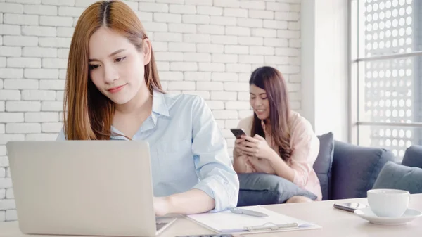 Attrayant intelligent créatif asiatique femmes d'affaires en vêtements décontractés intelligents de travail sur ordinateur portable tout en étant assis sur le bureau sur le bureau. Lifestyle femmes travaillent au bureau concept . — Photo