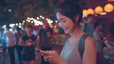 Gezgin Asya blogger kadınlar Bangkok seyahat, Tayland, güzel kadın Khao San Road sosyal medya kontrol cep telefonu kullanarak. Tayland kavramı kadınlar seyahat.