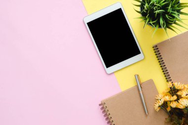Ofis Masası adlı kullanıcının alanı - düz çalışma üstten görünüm fotoğraf çalışma alanı boş sahte tablet, ağaç bitki ve defter pastel zemin üzerine yatırın. Pastel pembe sarı renkli kopya alanı çalışma Resepsiyon kavramı.