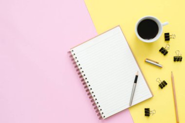 Yaratıcı düz fotoğraf çalışma masası yatıyordu. Üstten Görünüm Ofis Masası sahte kadar dizüstü bilgisayarlar, bitki, pastel renkli arka plan üzerinde kahve Kupası ve kopya alanı ile. Kopya alanı, düz yatıyordu fotoğraf ile Üstten Görünüm.