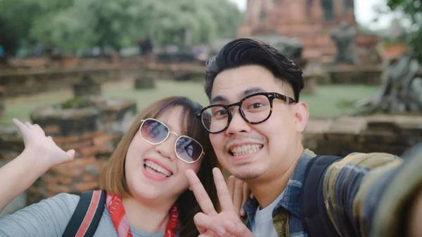 Voyageur couple asiatique en utilisant smartphone prendre selfie tout en passant un voyage de vacances à Ayutthaya, Thaïlande, Couple profiter de leur voyage à un point de repère incroyable dans la ville traditionnelle . — Photo