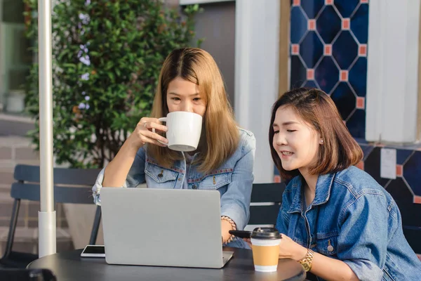 Les jeunes femmes asiatiques en vêtements décontractés intelligents qui travaillent en envoyant des e-mails sur ordinateur portable et en buvant du café tout en étant assis dans un café. Lifestyle femmes communication et travail dans le concept de café . — Photo