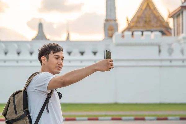 El bloguero asiático viaja en Bangkok, Tailandia, el hombre mochilero que usa el teléfono móvil hace vlog y vive en las redes sociales mientras pasa un tiempo dulce en un viaje de vacaciones. Estilo de vida de los hombres viajan en concepto de ciudad . —  Fotos de Stock