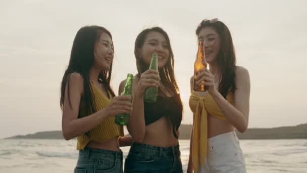 一群亚洲少女在沙滩上聚会庆祝 晚上日落时 朋友们在沙滩上愉快地喝啤酒 户外旅游假期假期夏季概念 慢动作拍摄 — 图库视频影像