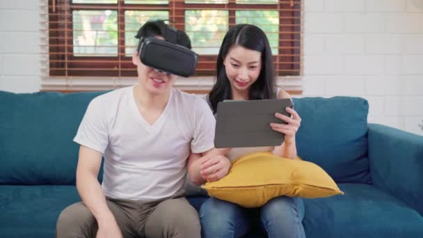 Ασιατικό Ζευγάρι Χρησιμοποιώντας Tablet Και Εικονική Πραγματικότητα Προσομοιωτή Παίζοντας Παιχνίδια — Αρχείο Βίντεο