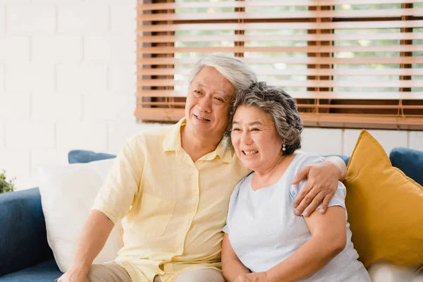 Asiatisches älteres Paar vor dem Fernseher im Wohnzimmer zu Hause, süßes Paar genießen Liebesmomente, während sie zu Hause entspannt auf dem Sofa liegen. Zeit genießen Lebensstil Familie zu Hause Konzept. — Stockfoto