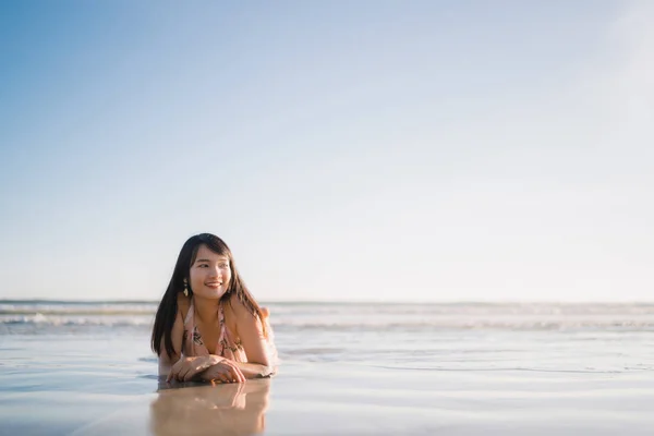 Young Asian woman feeling happy on beach, beautiful female happy relax smiling fun on beach near sea when sunset in evening. Lifestyle women travel on beach concept. — Stock Photo, Image