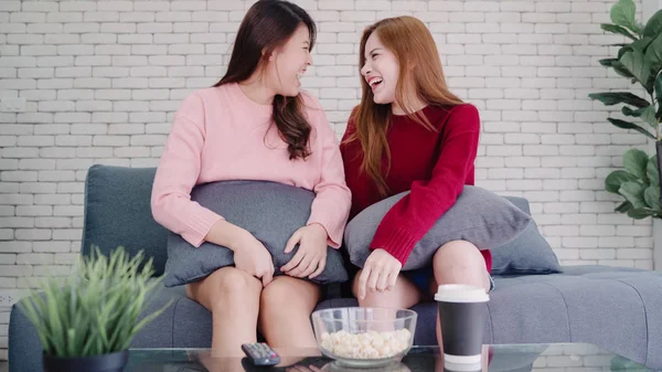 Lesbienne asiatique couple regarder la télévision rire et manger pop-corn dans le salon à la maison . — Photo