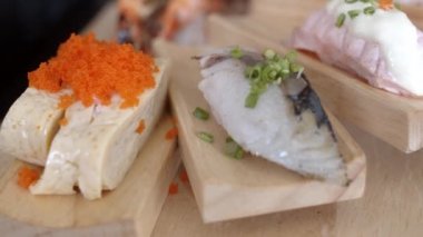 Japon restoranında suşi yiyen Asyalı kadın, yaz aylarında öğle yemeğinde yemek yiyen genç kadın. Yaşam tarzı kadınlar geleneksel gıda kavramı yiyor. Yavaş çekim çekimi.