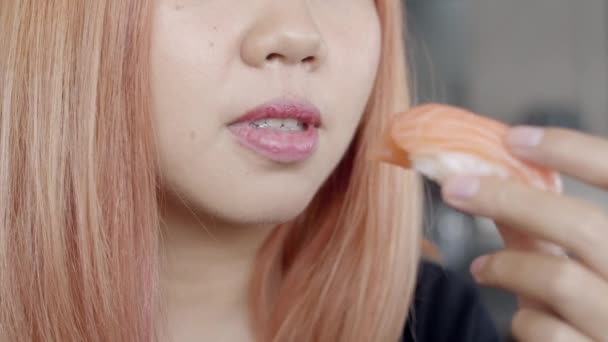 亚洲妇女在日本餐厅吃寿司 年轻女性在夏天的午餐时间吃鲑鱼寿司 生活方式女性吃传统食物的概念 慢动作拍摄 — 图库视频影像