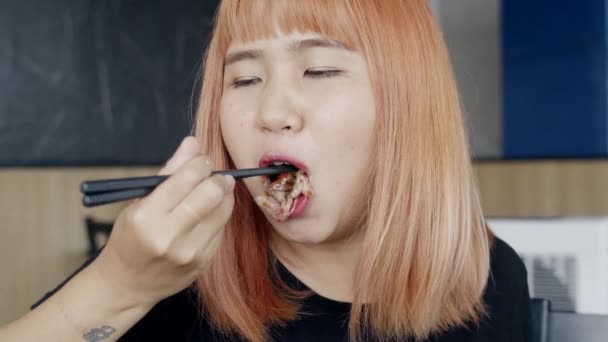 日本食レストランで寿司を食べるアジア人女性 夏のランチタイムに箸を持つ若い女性 和牛寿司を食べる 伝統的な食べ物を食べるライフスタイルの女性たち スローモーションショット — ストック動画