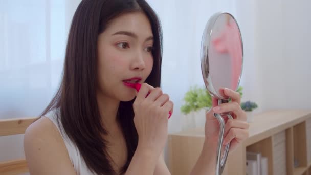 口紅を使用して若いアジアの女性は フロントミラーでメイクアップ 自宅で寝室で働く準備ができて自分自身を改善するために美容化粧品を使用して幸せな女性 家庭のライフスタイル女性のコンセプト スローモーションショット — ストック動画