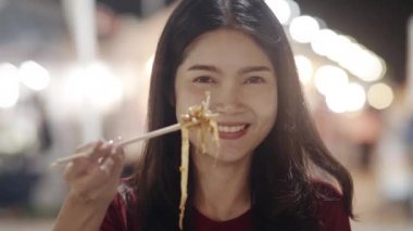 Bangkok Asya genç kadın seyahat, Tayland, güzel kadın duygu mutlu yürüyüş ve Khao San Road Pad Tay yeme. Kadınlar Tayland kavramı sokak gıda yemek seyahat. Yavaş çekim çekimi.