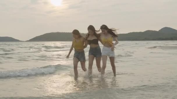 一群亚洲年轻女性在沙滩上散步 朋友们开心地放松一下 在傍晚日落时在海边的海滩上玩耍 生活方式朋友旅游假期暑假概念 慢动作拍摄 — 图库视频影像