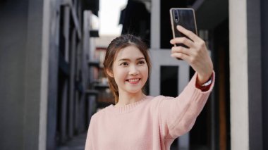Beijing, Çin mahallesinde, seyahat ederken selfie alarak smartphone kullanan neşeli güzel genç Asyalı backpacker blogger kadın. Yaşam tarzı sırt çantası turizm seyahat tatil kavramı.