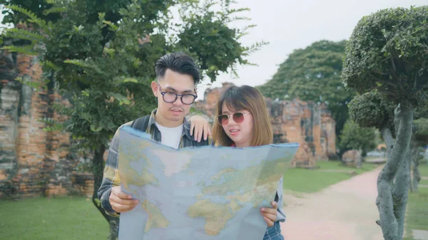 Traveler Asian couple direction and looking on location map while spending holiday trip at Ayutthaya, Thailand, backpacker couple enjoy journey in traditional city. Lifestyle couple travel concept.