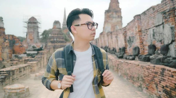 Viajante asiático homem passar férias viagem em Ayutthaya, Tailândia, mochileiro macho desfrutar de sua viagem no marco incrível na cidade tradicional. Estilo de vida homens viajar férias conceito . — Fotografia de Stock