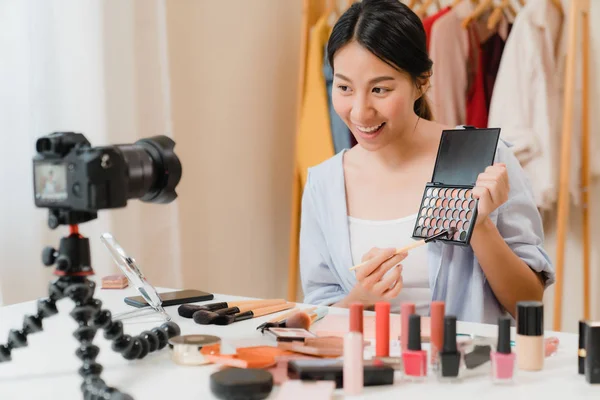 Skjønnhetsblogger presenterer skjønnhetskosmetikk foran kamera for opptak av video. Vakker asiatisk kvinne bruker kosmetikk til å lage en veiledende kringkastingsvideo til sosiale nettverk via Internett . – stockfoto