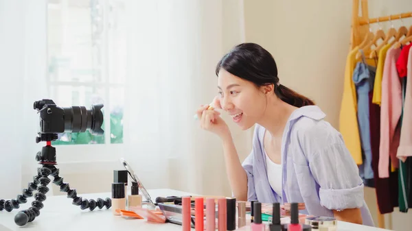 Kauneus bloggaaja esittää kauneus kosmetiikka istuu edessä kamera videotallennukseen. Onnellinen kaunis nuori aasialainen nainen käyttää kosmetiikkaa tarkastelu muodostavat opetusohjelma lähettää suorana video sosiaalinen verkosto . — kuvapankkivalokuva