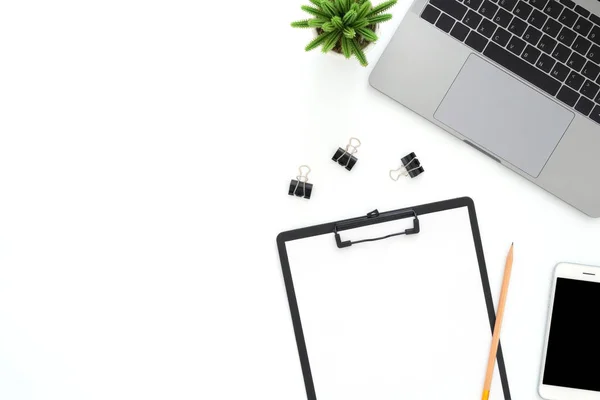 Creative flat lay photo of workspace desk. Top view office desk with laptop, phone, pencil, blank clipboard and plant on white color background. Top view with copy space, flat lay photography.