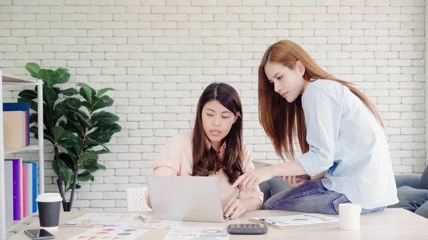 Attrayant intelligent créatif asiatique femmes d'affaires en vêtements décontractés intelligents de travail sur ordinateur portable tout en étant assis sur le bureau sur le bureau. Les femmes travaillent au bureau concept . — Photo