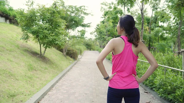 健康美丽的年轻亚洲运动员在运动服装腿变暖, 伸展双臂, 准备在城市公园街头跑步。生活方式活跃的妇女锻炼在城市概念. — 图库照片