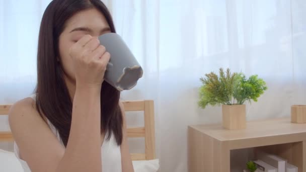 Счастливая Красивая Азиатская Женщина Улыбается Пьет Чашку Кофе Чая Кровати — стоковое видео