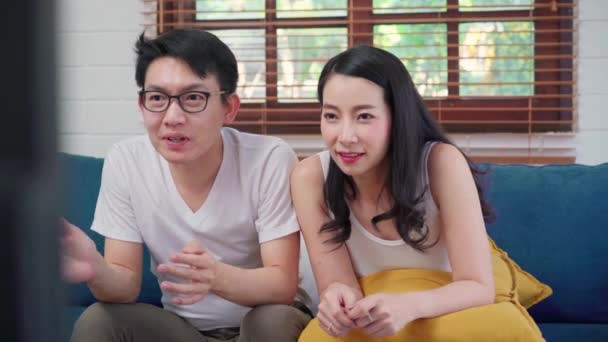 Pasangan Asia Bersorak Pertandingan Sepak Bola Depan Ruang Tamu Televisi — Stok Video