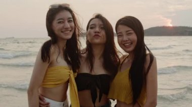 Akıllı telefon vlog video kullanarak genç kadın ve plajda sosyal medyada canlı, Güzel kadın akşam gün batımında denize yakın plajda dinlenmek. Plaj yaz konseptinde kadın seyahati. Yavaş çekim çekimi.