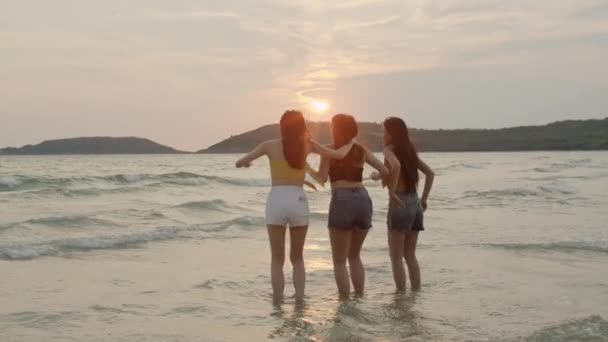 ビーチでジャンプするアジアの若い女性のグループは 友人は夕方の日没時に海の近くのビーチで遊んで楽しいリラックスしてリラックスします ライフスタイルの友人旅行休暇休暇夏のコンセプト スローモーションショット — ストック動画