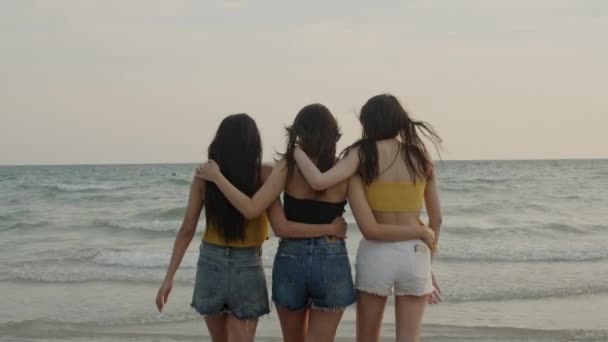 ビーチを歩くアジアの若い女性のグループは 友人は夕方の日没時に海の近くのビーチで遊んで楽しいリラックスしてリラックスします ライフスタイルの友人旅行休暇休暇夏のコンセプト スローモーションショット — ストック動画