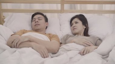 Asyalı çift eşi yatak odasında uyku zaman Snore kocası rahatsız, çift evde kadın uykusuzluk yatakta yatan ve uyuyamıyorum. Çift evde uyku kavramı.