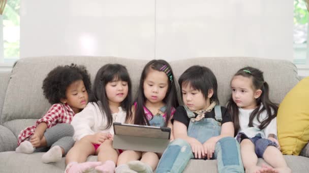 教室でタブレットを使う子どもたち 小学生の勉強や遊びに技術を使って幸せな多民族の少年少女たち 子供たちは教育の概念のために技術を使用します — ストック動画
