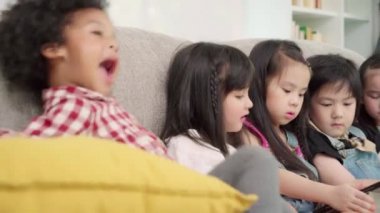 Sınıfta tablet kullanan bir grup çocuk, çok ırklı genç erkek ve kız ilkokulda eğitim ve oyun için teknolojiyi kullanmaktan mutluluk duyabiliyor. Çocuklar eğitim konsepti için teknolojiyi kullanıyor.