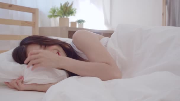 亚洲妇女微笑着躺在床上的卧室 美丽的日本女性利用放松时间醒来后在家里 生活方式妇女使用放松时间在家里的概念 慢动作拍摄 — 图库视频影像