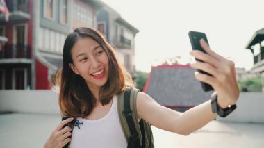 Beijing, Çin mahallesinde, seyahat ederken selfie alarak smartphone kullanan neşeli güzel genç Asyalı backpacker blogger kadın. Yaşam tarzı sırt çantası turizm seyahat tatil kavramı.