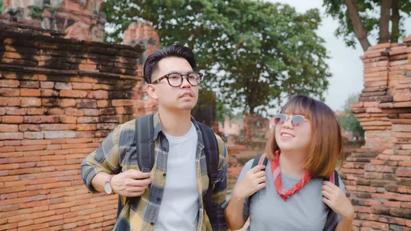 Traveler Asian couple spending holiday trip at Ayutthaya, Thailand, backpacker sweet couple enjoy their journey at amazing landmark in traditional city. Lifestyle couple travel holidays concept.