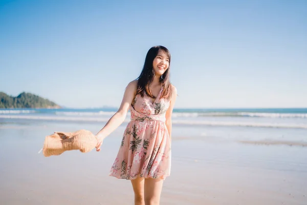 Jovem mulher asiática andando na praia. Bela fêmea feliz relaxar andando na praia perto do mar quando o pôr do sol à noite. Estilo de vida as mulheres viajam no conceito de praia . — Fotografia de Stock