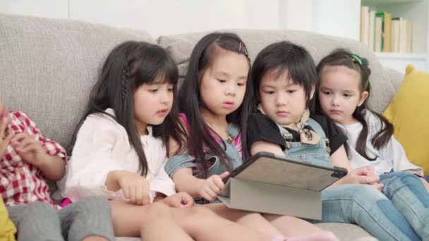 教室でタブレットを使う子どもたち 小学生の勉強や遊びに技術を使って幸せな多民族の少年少女たち 子供たちは教育の概念のために技術を使用します — ストック動画