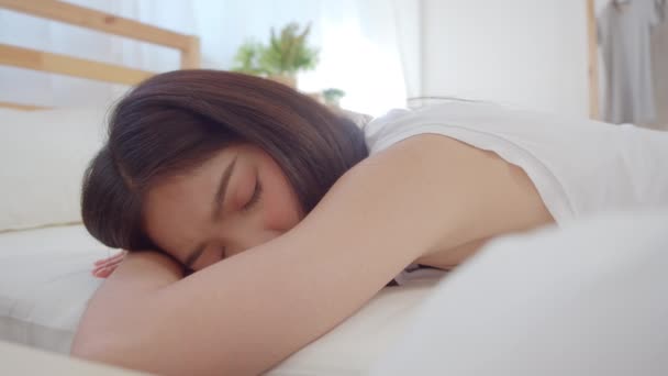 亚洲妇女微笑着躺在床上的卧室 美丽的日本女性利用放松时间醒来后在家里 生活方式妇女使用放松时间在家里的概念 慢动作拍摄 — 图库视频影像