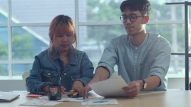 Genç Asya yaratıcı takım toplantıdan sonra masa temizleyin. İş adamı ve kadın grubu, modern ofis konseptinde iş durumu, takım çalışması işini bitirdiğinde kağıt bırakma yı organize ediyor.