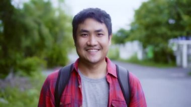 Asyalı yürüyüşçü adam ormanda trekking. Genç mutlu sırt çantası erkek kameraya gülümseyen, seyahat doğa ve macera gezisi, bahar tatili tatil konsepti nde ağaç dağ çok tırmanmak.