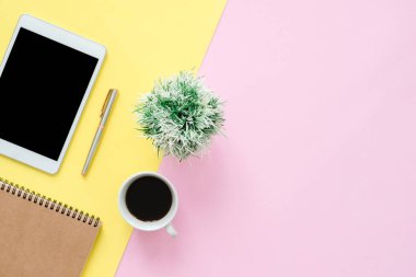 Ofis Masası adlı kullanıcının alanı - düz çalışma üstten görünüm fotoğraf çalışma alanı boş sahte tablet, kahve fincanı ve defter pastel zemin üzerine yatırın. Pastel pembe sarı renkli kopya alanı çalışma Resepsiyon kavramı.