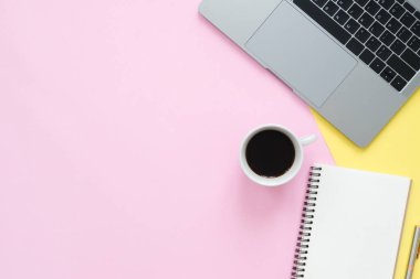 Yaratıcı düz fotoğraf çalışma masası yatıyordu. Üstten Görünüm ofis büro dizüstü bilgisayar, boş boş defter ve kahve fincanı pastel renk arka plan üzerinde. Kopya alanı, düz yatıyordu fotoğraf ile Üstten Görünüm.