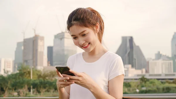 Iloinen aasialainen turisti bloggaaja nainen, joka käyttää älypuhelinta suuntaan ja etsii sijaintikarttaa matkustaessaan kadulla keskustassa. Elämäntapa reppu turisti matka loma käsite . — kuvapankkivalokuva