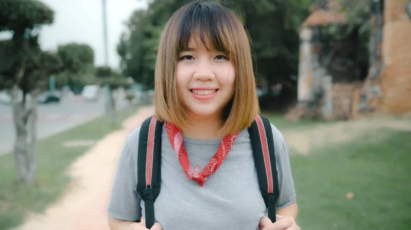 Viajero asiático mujer sintiéndose feliz sonriendo a cámara viaje de vacaciones en Ayutthaya, Tailandia, mochilero mujer disfrutar de su viaje en el punto de referencia increíble en la ciudad tradicional. Estilo de vida viaje vacaciones concepto —  Fotos de Stock