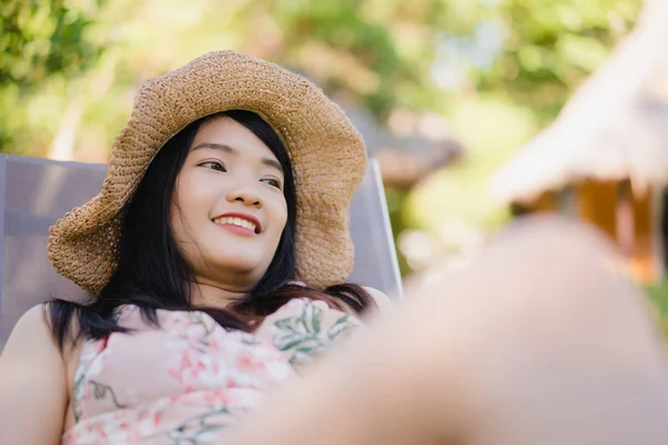 Jovem mulher asiática sentada no banco relaxar na praia, bela mulher feliz relaxar perto do mar. Estilo de vida as mulheres viajam no conceito de praia . — Fotografia de Stock